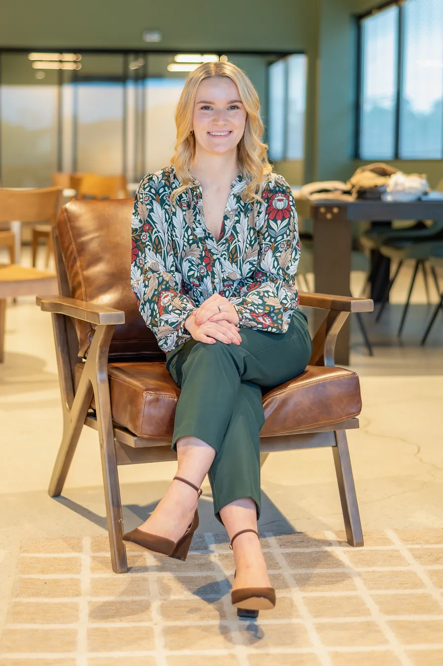 Dr. Kate seated in a leather armchair in a bright, modern office
